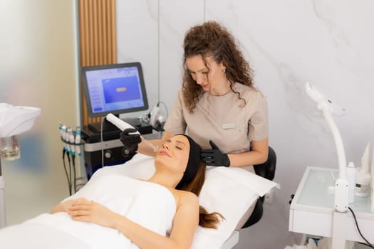 A skilled therapist employs high frequency therapy on a client's face, promoting skin health and relaxation in a tranquil spa environment. The atmosphere radiates comfort and care.