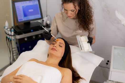 A beauty therapist applies a rejuvenating cream to a client's face, aiming to enhance moisture and reduce wrinkles. The treatment unfolds in a tranquil salon environment.