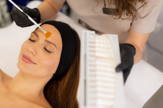 A beauty therapist applies a rejuvenating cream to a client's face, aiming to enhance moisture and reduce wrinkles. The treatment unfolds in a tranquil salon environment.