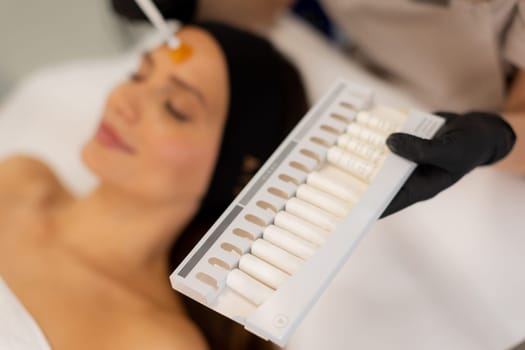 In a tranquil wellness center, a skilled professional applies a high moisturizing cream to a client's forehead, enhancing relaxation and rejuvenation.