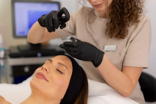 A skilled aesthetician applies a rejuvenating serum to a client's forehead, creating a relaxing atmosphere filled with calm and care, promoting skin health and radiance.