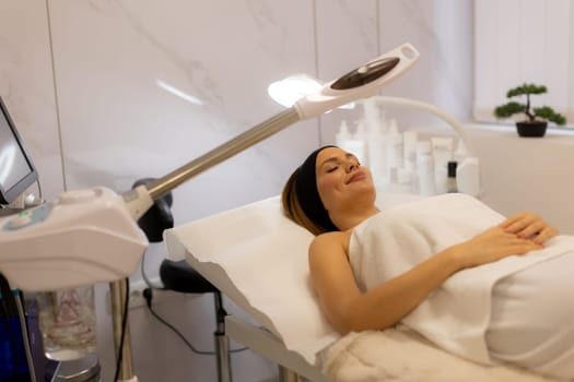 A tranquil spa setting features a woman enjoying a facial treatment, with mist enveloping her face. The atmosphere promotes relaxation and skincare rejuvenation.
