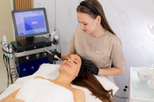 A skilled practitioner uses a microneedling mesotherapy device to revitalize a client's skin. The serene beauty clinic atmosphere complements the transformative treatment experience.