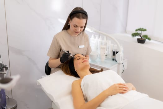 A skilled practitioner uses a microneedling mesotherapy device to revitalize a client's skin. The serene beauty clinic atmosphere complements the transformative treatment experience.