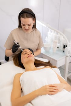 A skilled practitioner performs microneedling on a relaxed client, enhancing skin texture and rejuvenation. The tranquil spa ambiance promotes a sense of calm and well-being.