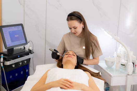 A skilled professional uses a microneedling mesotherapy device on a client in a serene clinic, focusing on skin rejuvenation and enhancing beauty. The environment is calm and sterile.
