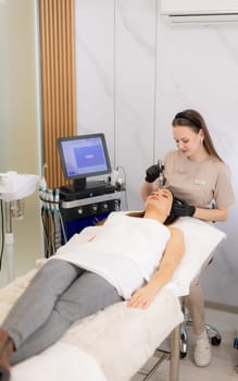A skilled professional uses a microneedling mesotherapy device on a client in a serene clinic, focusing on skin rejuvenation and enhancing beauty. The environment is calm and sterile.