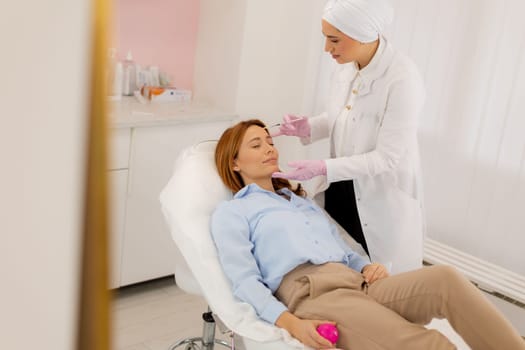 Patient relaxes on a comfortable treatment bed while a skilled practitioner applies dermal filler to enhance facial features in a tranquil clinic environment.