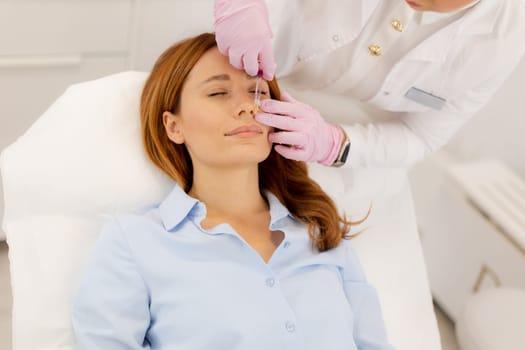 A woman enjoys a refreshing skincare procedure, lying comfortably as a skilled practitioner applies nourishing serum. The atmosphere is calming, promoting relaxation and wellness.