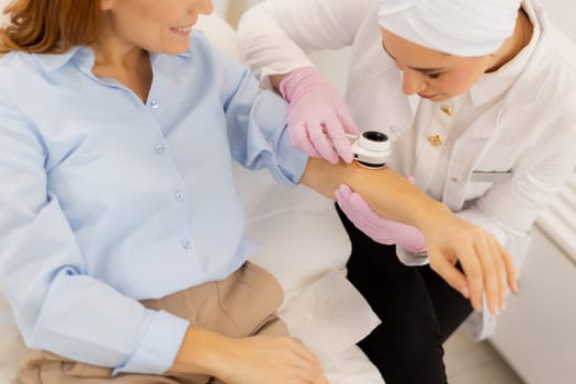 A skilled practitioner conducts a dermatoscopic examination, closely inspecting a patient's skin. The caring environment ensures precise assessment of any concerns.