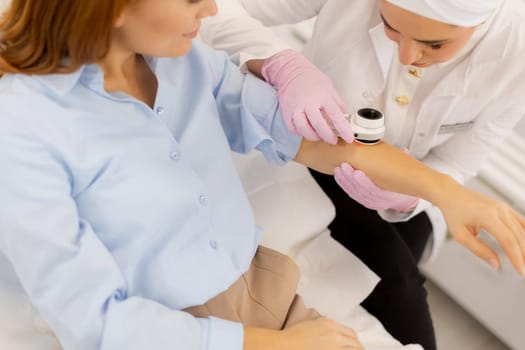 A skilled practitioner conducts a dermatoscopic examination, closely inspecting a patient's skin. The caring environment ensures precise assessment of any concerns.