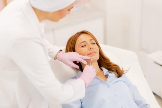 A skilled practitioner applies lip filler to a relaxed client in a calm clinic environment.