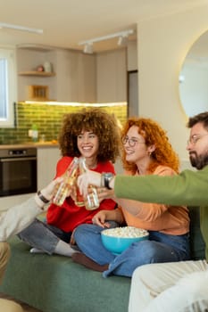 Friends gather in a stylish living room, raising glasses filled with refreshing drinks. They share laughter and warmth while surrounded by a bowl of popcorn, creating joyful memories