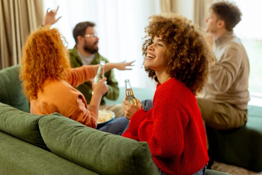 Four friends gather in a cozy living room, sharing laughter and drinks while seated on a comfy sofa. The atmosphere is warm and inviting, perfect for enjoying each other's company.