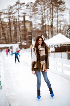 Portrait of young woman rides ice skates in the park