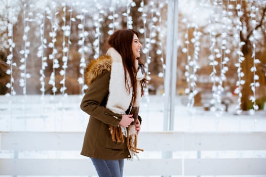 Portrait of young woman in winter park at Christmas market