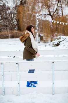 Portrait of young woman rides ice skates in the park