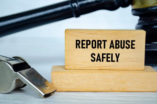 Protect abuse safely text on wooden blocks with whistle and lawyer gavel background.