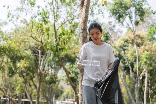 A volunteer happily collects plastic waste, demonstrating commitment to sustainability and environmental health during a cleanup.