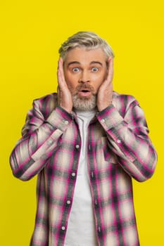 Oh my God, Wow. Excited amazed winner Caucasian man raising hands in surprise looking at camera with big eyes shocked victory goal celebrating success achievement good news. Guy on yellow background
