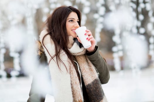 Pretty young woman drinking hot tea on a cold winter day