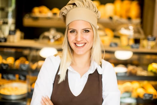 Beautiful young woman smiling confidently posing in her baker shop