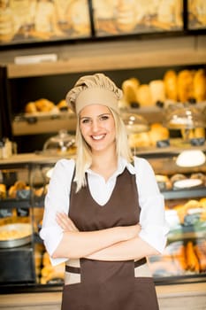 Beautiful young woman smiling confidently posing in her baker shop
