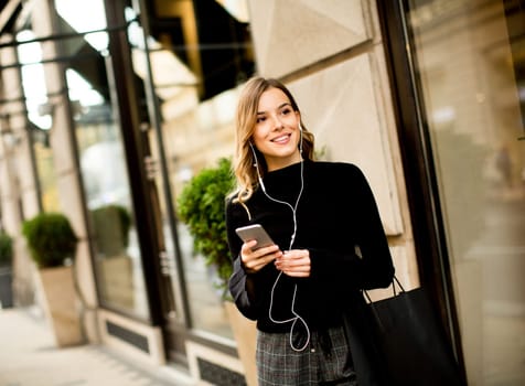 Portrait of young woman  listening music outdoor