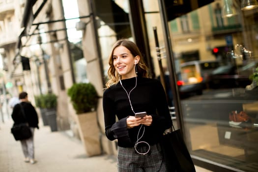 Portrait of modern young shopaholic woman on street