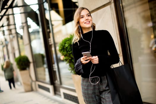 Portrait of modern young shopaholic woman on street