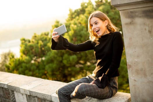 Pretty young woman teking selfie outdoor