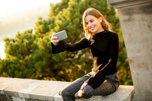 Pretty young woman teking selfie outdoor