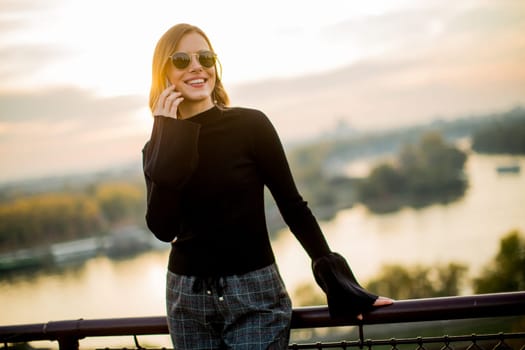 Portrait of young woman with mobile phone outdoor