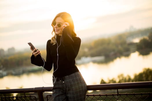 Portrait of attractive young woman with mobile phone outdoor