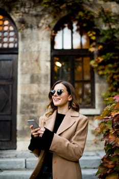 View at modern woman using mobile phone at autumn outdoor