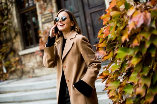 View at modern woman using mobile phone at autumn outdoor
