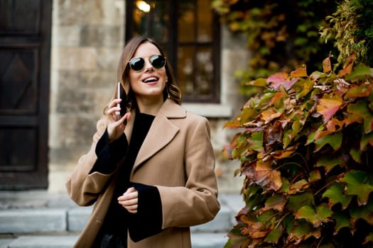 Portrait of modern woman using mobile phone at autumn outdoor