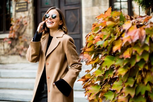 View at modern woman using mobile phone at autumn outdoor