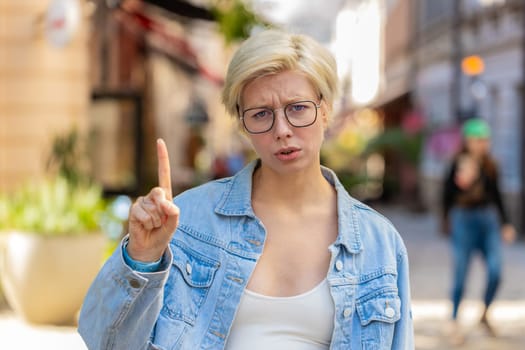 Displeased upset Caucasian woman reacting to unpleasant awful idea, dissatisfied with bad quality, wave hand, shake head No, dismiss idea, dont like proposal. Young blonde lady traveler on city street