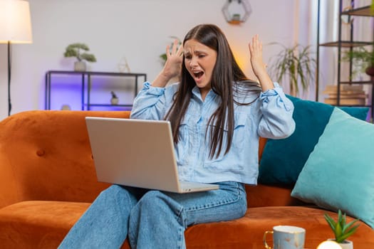 Angry stressed young Caucasian woman talking laptop using computer webcam video call on couch dissatisfied friend or boyfriend and irritated, talking solve issue conflict stress quarrel. Lifestyles