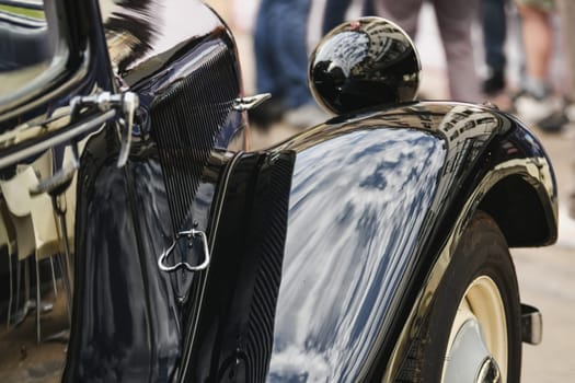 Close up. Macro. Detail of an old vintage black car. Shiny hood, wheel