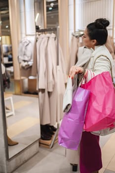 Shopping enthusiast admires her outfit in a stylish boutique mirror