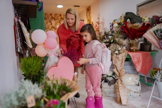 A mother and her daughter explore a colorful flower shop, admiring bouquets and beautiful floral arrangements. The child, wearing a backpack, is captivated by the vibrant colors.