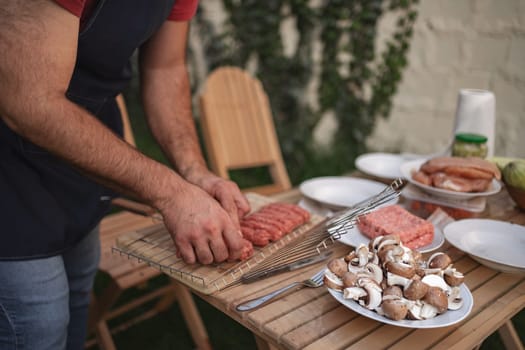 Preparing delicious sausages and mushrooms for a fun outdoor barbecue event.