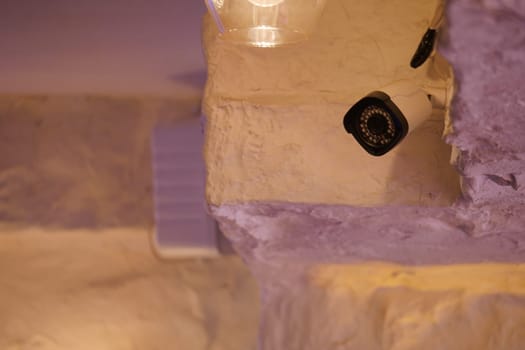 A security camera is positioned on a light-colored wall, monitoring the area.
