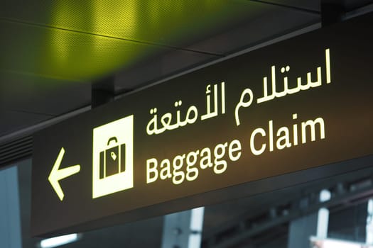 Directional sign indicating baggage claim area inside the airport terminal.