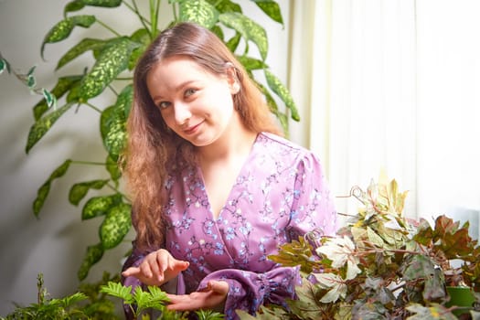 A young woman gently caring for her indoor plants, surrounded by vibrant greenery in a bright, sunlit room.