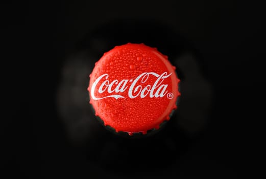 Gaziveren Cyprus -08.03.2025 Coca cola A vibrant red soda cap covered in beads of water shines brightly in the dark, inviting thirst and nostalgia.
