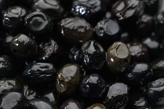 Lustrous black olives showcase their vibrant surfaces, awaiting to elevate dishes with rich flavor and texture.