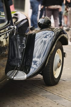 DIEPPE, FRANCE - MAY, 15, 2022: Detail of an old black Citroen Traction Avant. Shiny hood, wheel